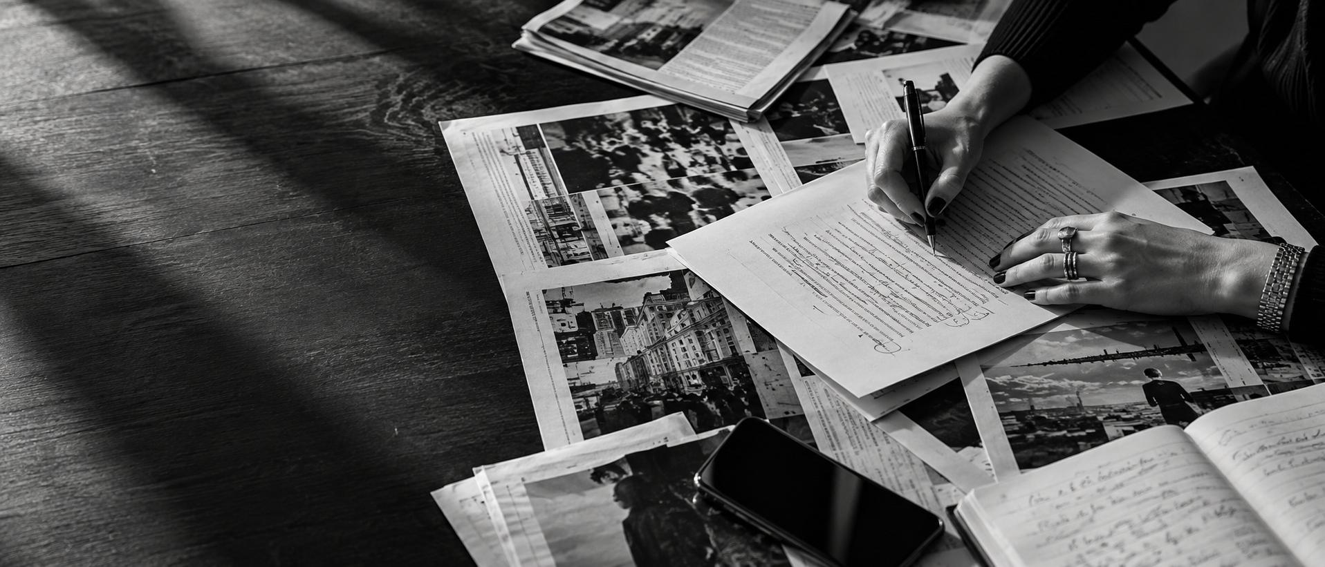 Hands marking up a story among press pages and notes